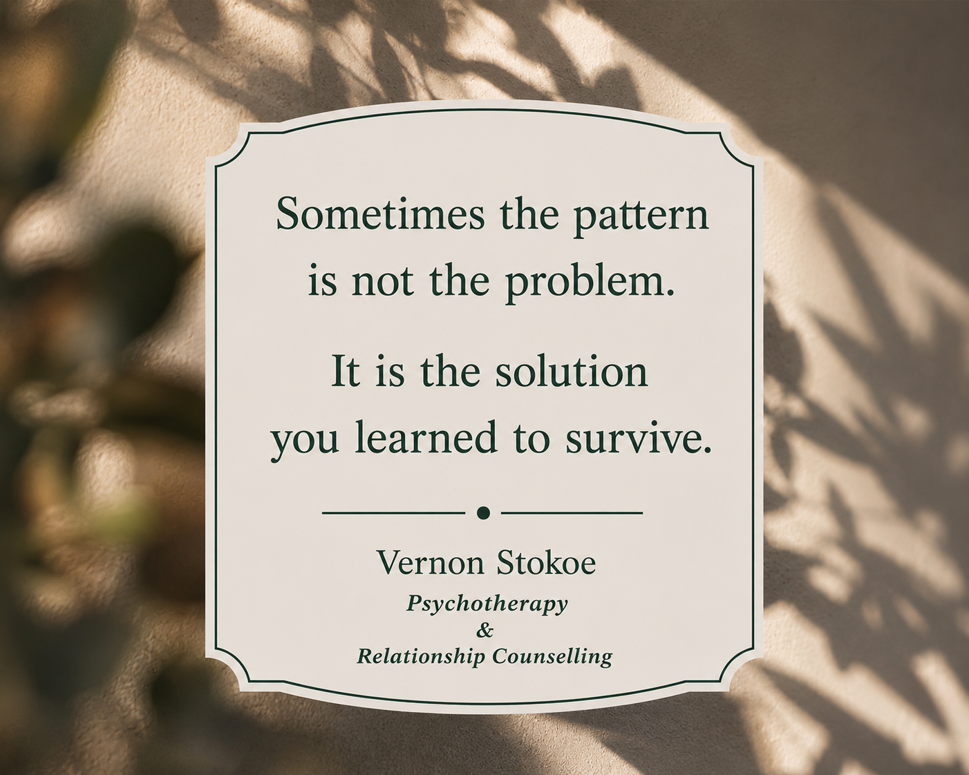 Psychotherapy quote graphic with soft wall shadows and blurred foreground leaves, featuring the text “Sometimes the pattern is not the problem. It is the solution you learned to survive.”
